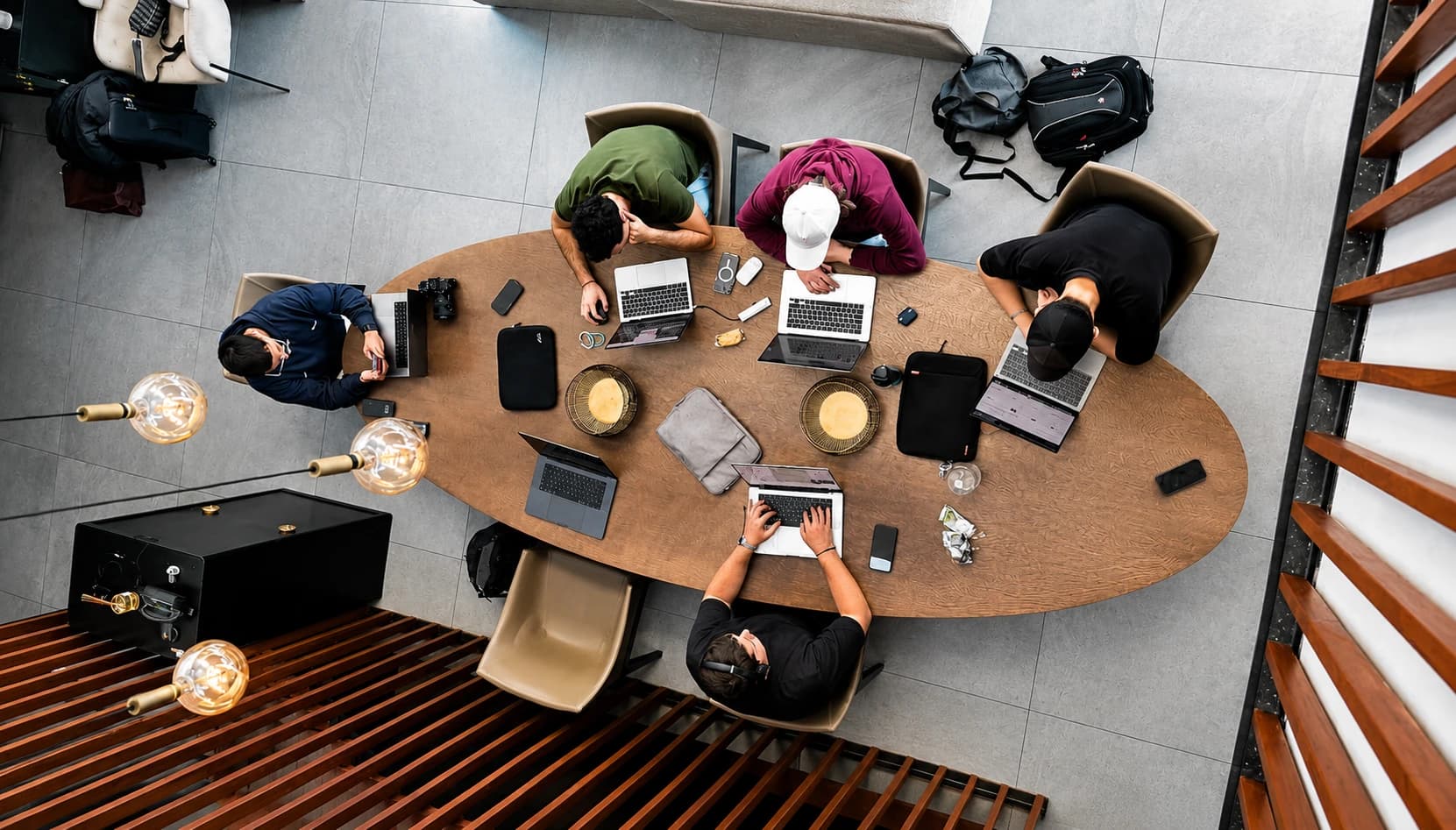 A team collaborating around a shared table, laptops open, supporting the infrastructure behind a business